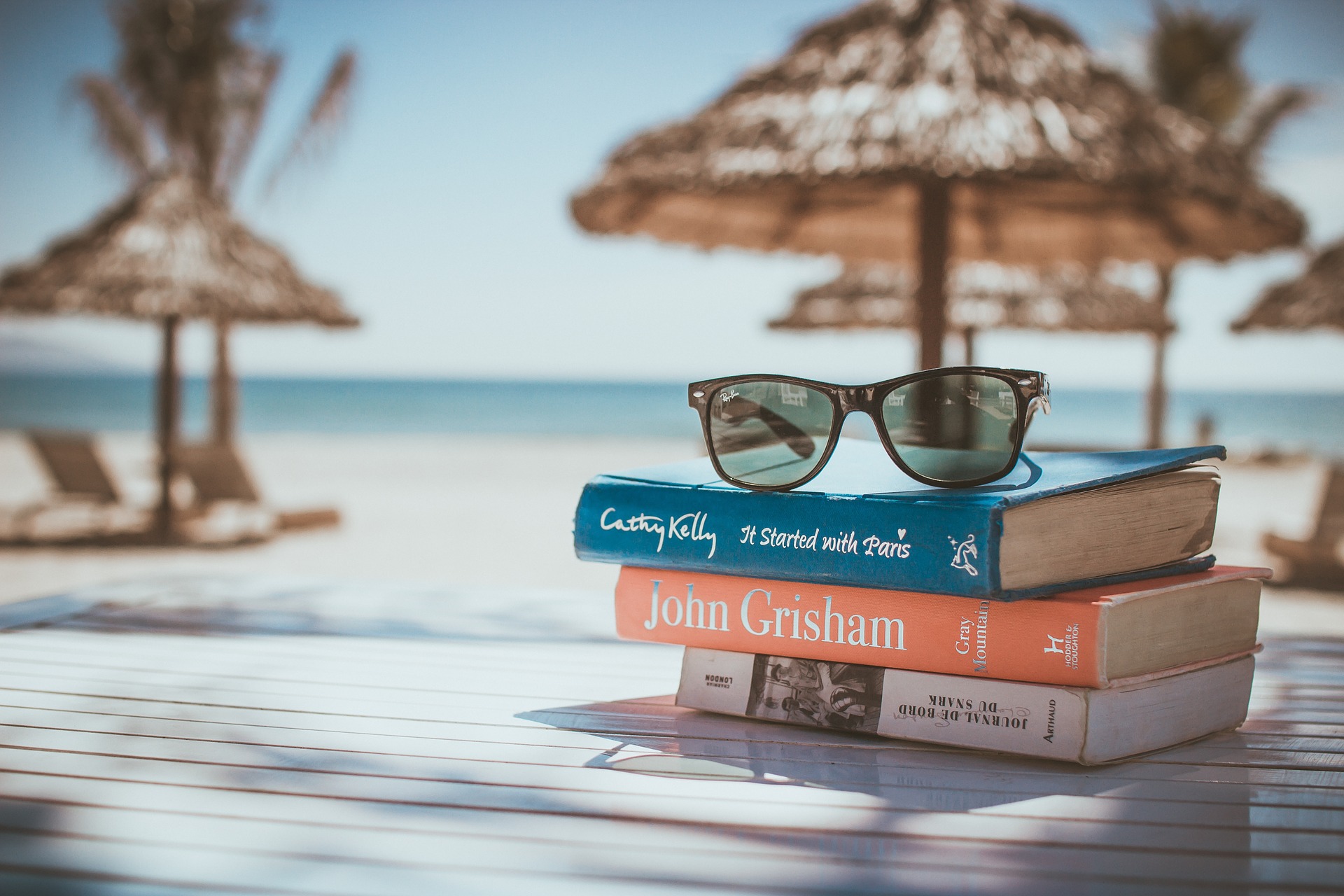 Bestsellery na wakacje – co warto zabrać do czytania na plażę?